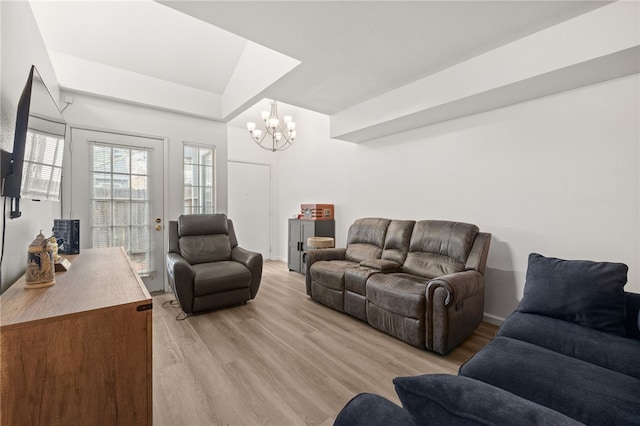 living area with light wood-type flooring and an inviting chandelier