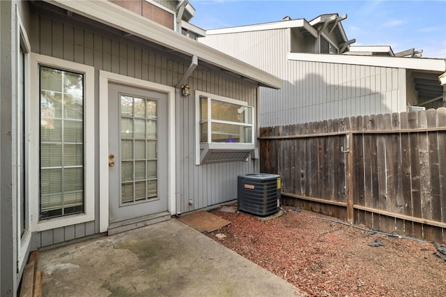 property entrance featuring central air condition unit and fence