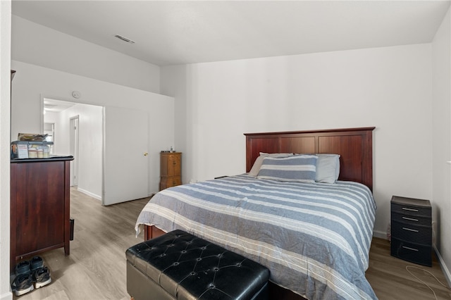 bedroom with visible vents, light wood-type flooring, and baseboards