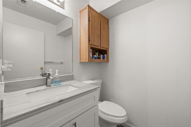 half bathroom featuring visible vents, toilet, and vanity