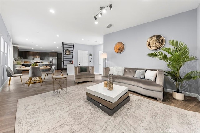 living room with light wood-style flooring, recessed lighting, visible vents, and baseboards