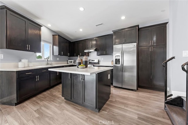 kitchen with visible vents, under cabinet range hood, a center island, appliances with stainless steel finishes, and light countertops