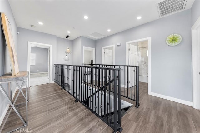 hallway with visible vents, an upstairs landing, wood finished floors, recessed lighting, and baseboards