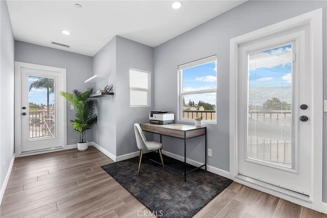 office space with recessed lighting, visible vents, baseboards, and wood finished floors