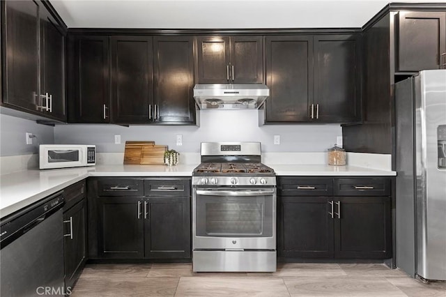 kitchen with light countertops, ventilation hood, and appliances with stainless steel finishes