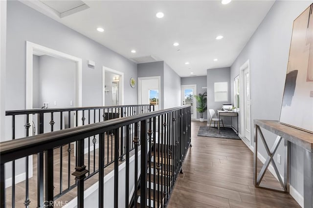 corridor featuring dark wood-type flooring, an upstairs landing, recessed lighting, and baseboards