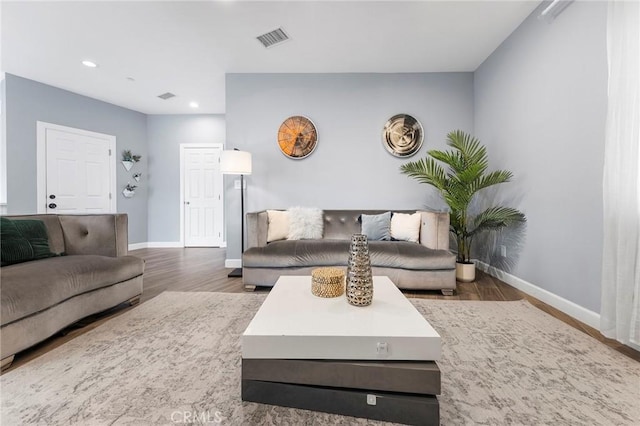 living area featuring recessed lighting, visible vents, baseboards, and wood finished floors