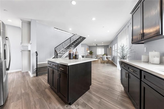 kitchen with stainless steel fridge, wood finished floors, and light countertops