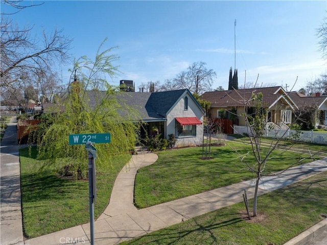 view of front of property with stucco siding, stone siding, a front yard, and fence