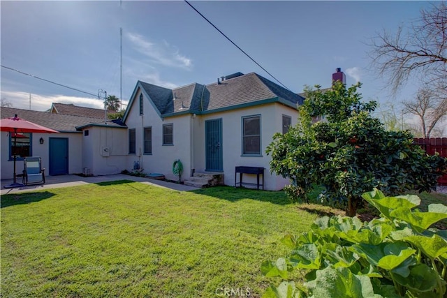 back of house featuring a patio, a yard, fence, and stucco siding