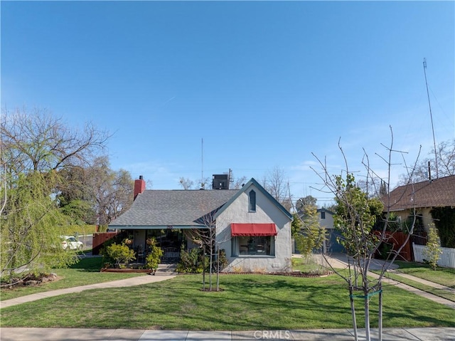 bungalow-style home with a front lawn, fence, roof with shingles, and a chimney