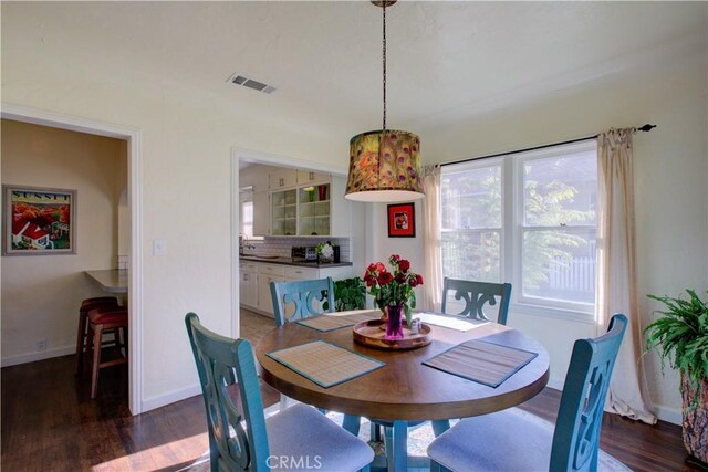 dining area with wood finished floors, visible vents, and baseboards