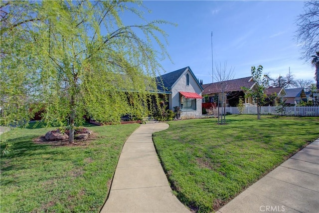 view of front facade with a front yard and fence