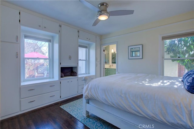 bedroom with dark wood finished floors, ensuite bathroom, and a ceiling fan