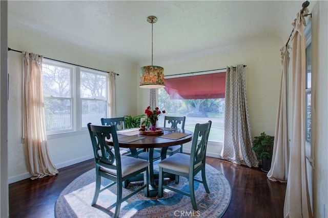 dining area with baseboards and dark wood-style flooring