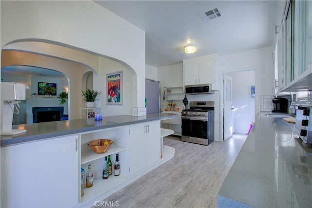 kitchen featuring visible vents, light wood finished floors, open shelves, appliances with stainless steel finishes, and white cabinetry