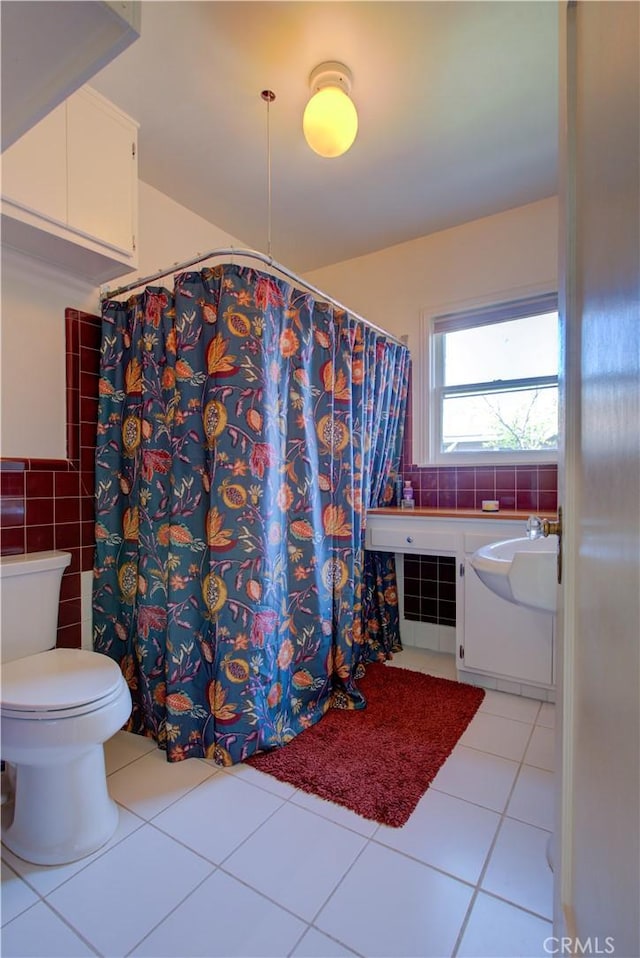 full bath with a shower with curtain, toilet, tile walls, and tile patterned flooring