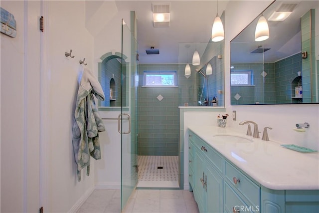 full bath with vanity, a shower stall, a healthy amount of sunlight, and tile patterned flooring