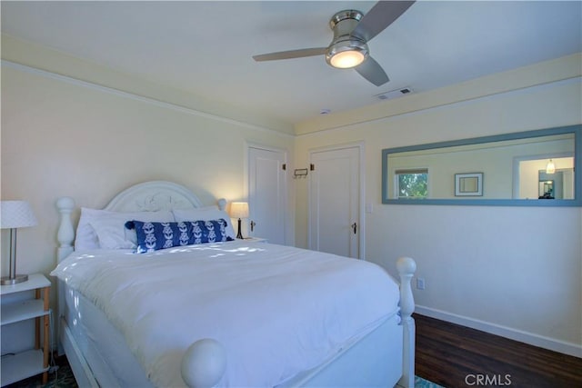 bedroom with a ceiling fan, wood finished floors, baseboards, and visible vents