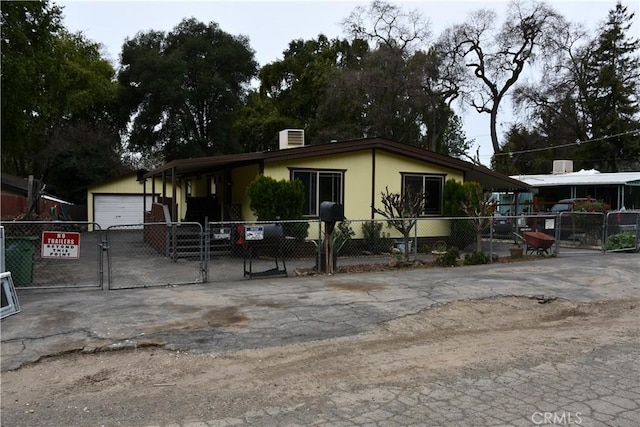 view of front of home featuring a gate, fence, central AC, an outdoor structure, and a garage