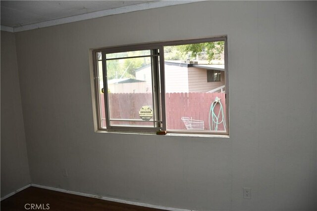 empty room featuring wood finished floors and baseboards