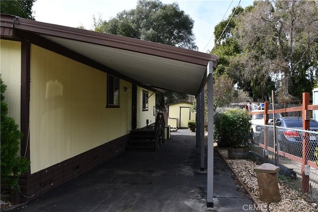 view of vehicle parking featuring a carport and fence