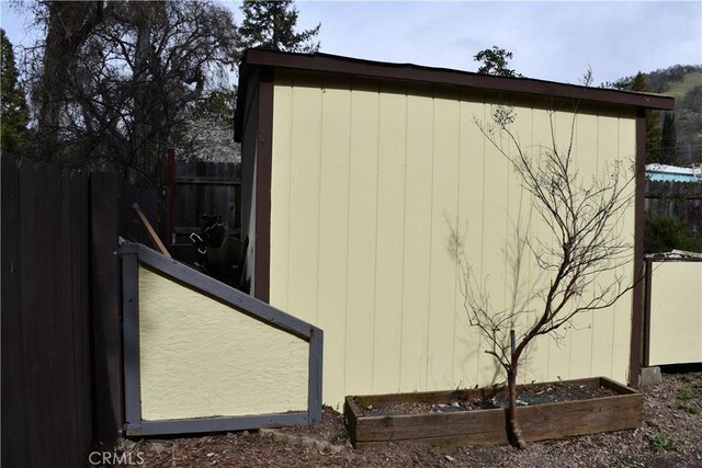 view of outbuilding with an outdoor structure, a vegetable garden, and fence