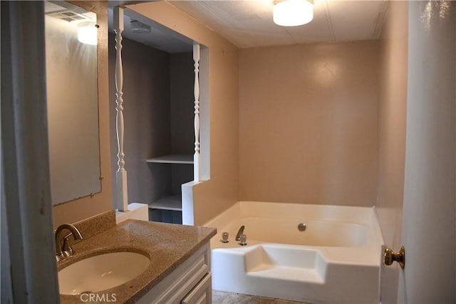 bathroom featuring a garden tub and vanity