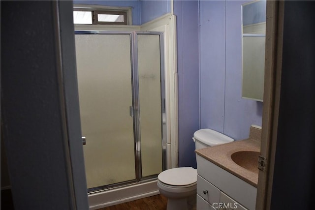 bathroom with vanity, a shower stall, toilet, and wood finished floors