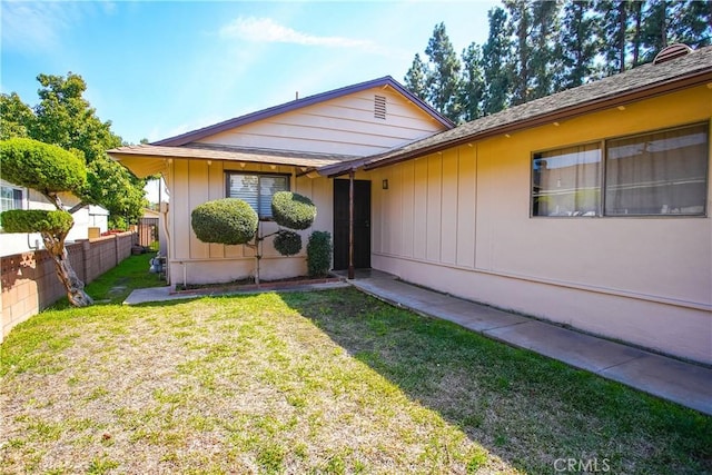 view of front of house with a front lawn and fence