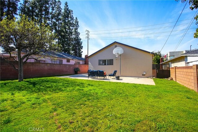 back of property with a patio area, stucco siding, a yard, and a fenced backyard