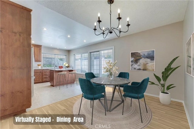 dining room with baseboards, recessed lighting, light wood-style floors, a notable chandelier, and a textured ceiling