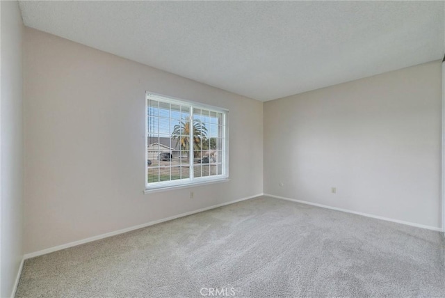 unfurnished room featuring carpet flooring, baseboards, and a textured ceiling