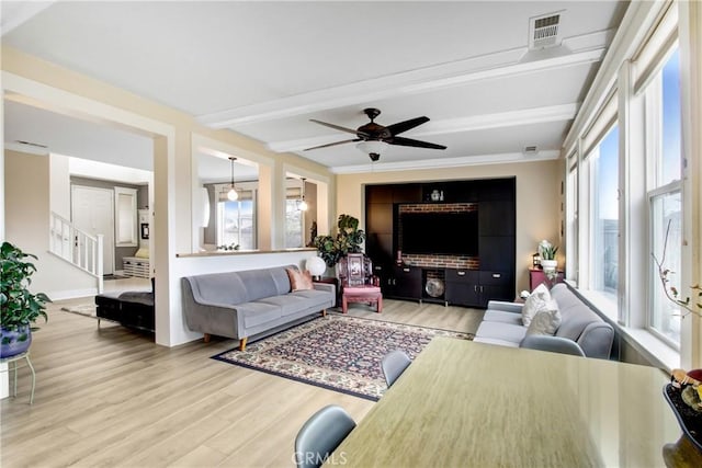 living area featuring visible vents, ceiling fan, stairs, beam ceiling, and wood finished floors