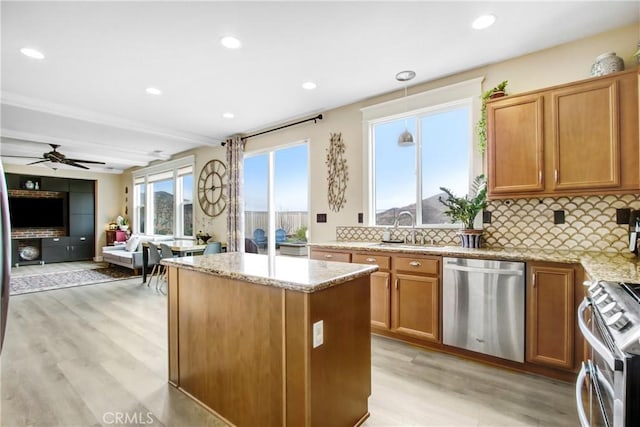 kitchen featuring decorative backsplash, light wood-style flooring, appliances with stainless steel finishes, and a sink