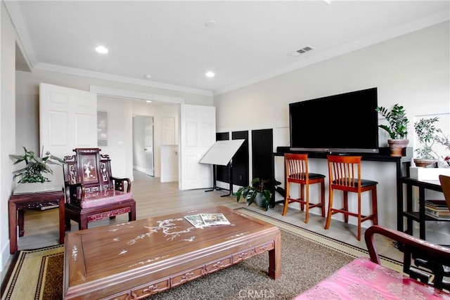 living area featuring recessed lighting, visible vents, wood finished floors, and crown molding