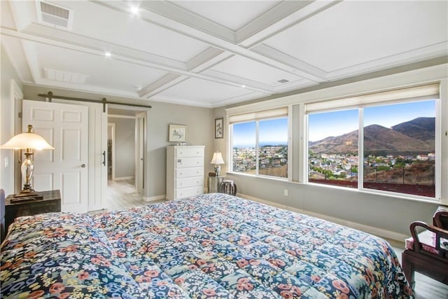 bedroom featuring a barn door, baseboards, visible vents, and coffered ceiling