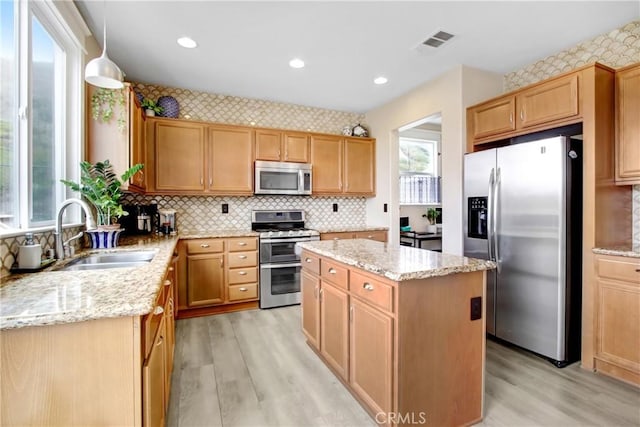 kitchen with visible vents, appliances with stainless steel finishes, light stone countertops, and a sink