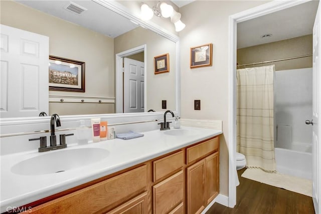 full bath with a sink, visible vents, toilet, and wood finished floors