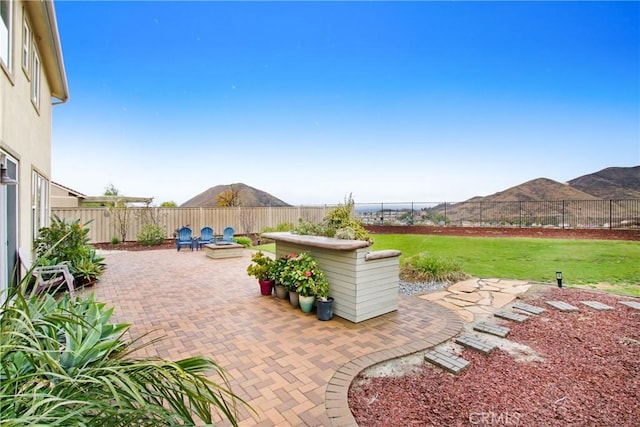 view of patio with a mountain view and a fenced backyard