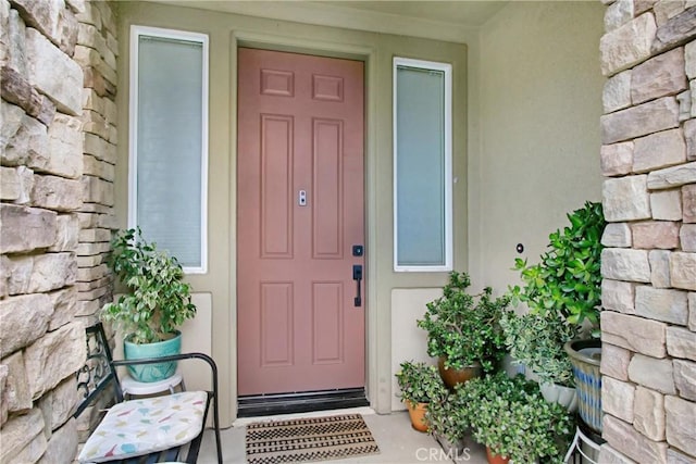 property entrance with stone siding and stucco siding