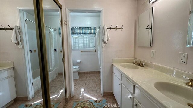 full bathroom with double vanity, toilet, and a sink