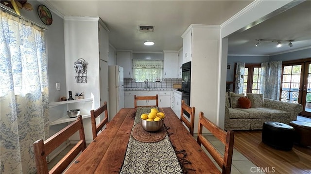 dining space with visible vents, crown molding, and wood finished floors