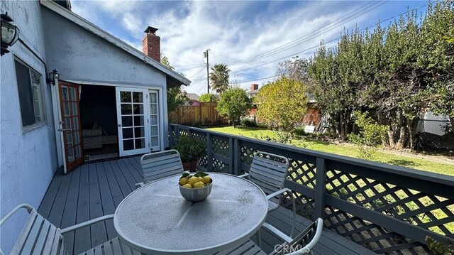 deck with outdoor dining area and a fenced backyard