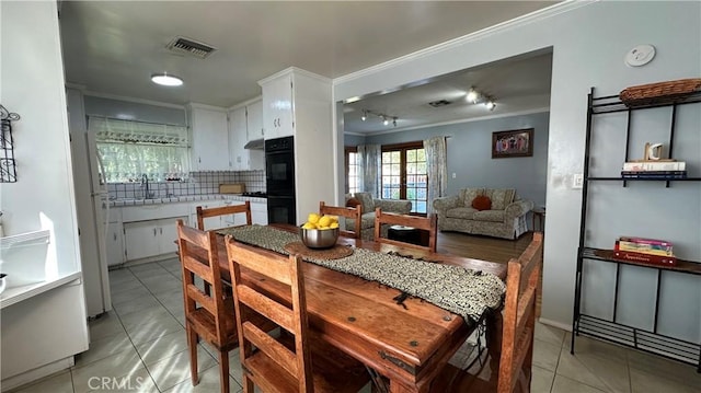 dining area featuring light tile patterned floors, visible vents, and ornamental molding