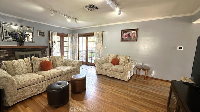 living area featuring visible vents, wood finished floors, ornamental molding, and french doors