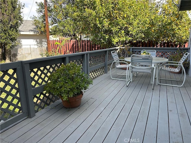 deck featuring outdoor dining space and fence