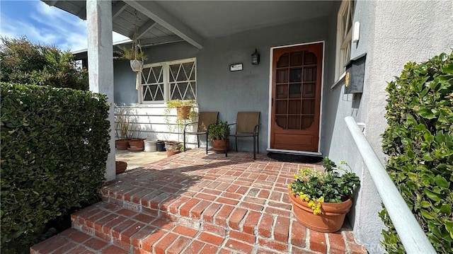 doorway to property featuring stucco siding