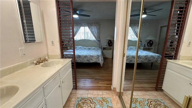 bathroom with double vanity, tile patterned flooring, ensuite bath, and a sink