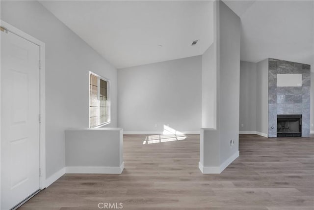 interior space featuring wood finished floors, a fireplace, and baseboards